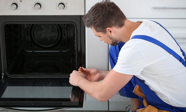 man fixing an oven